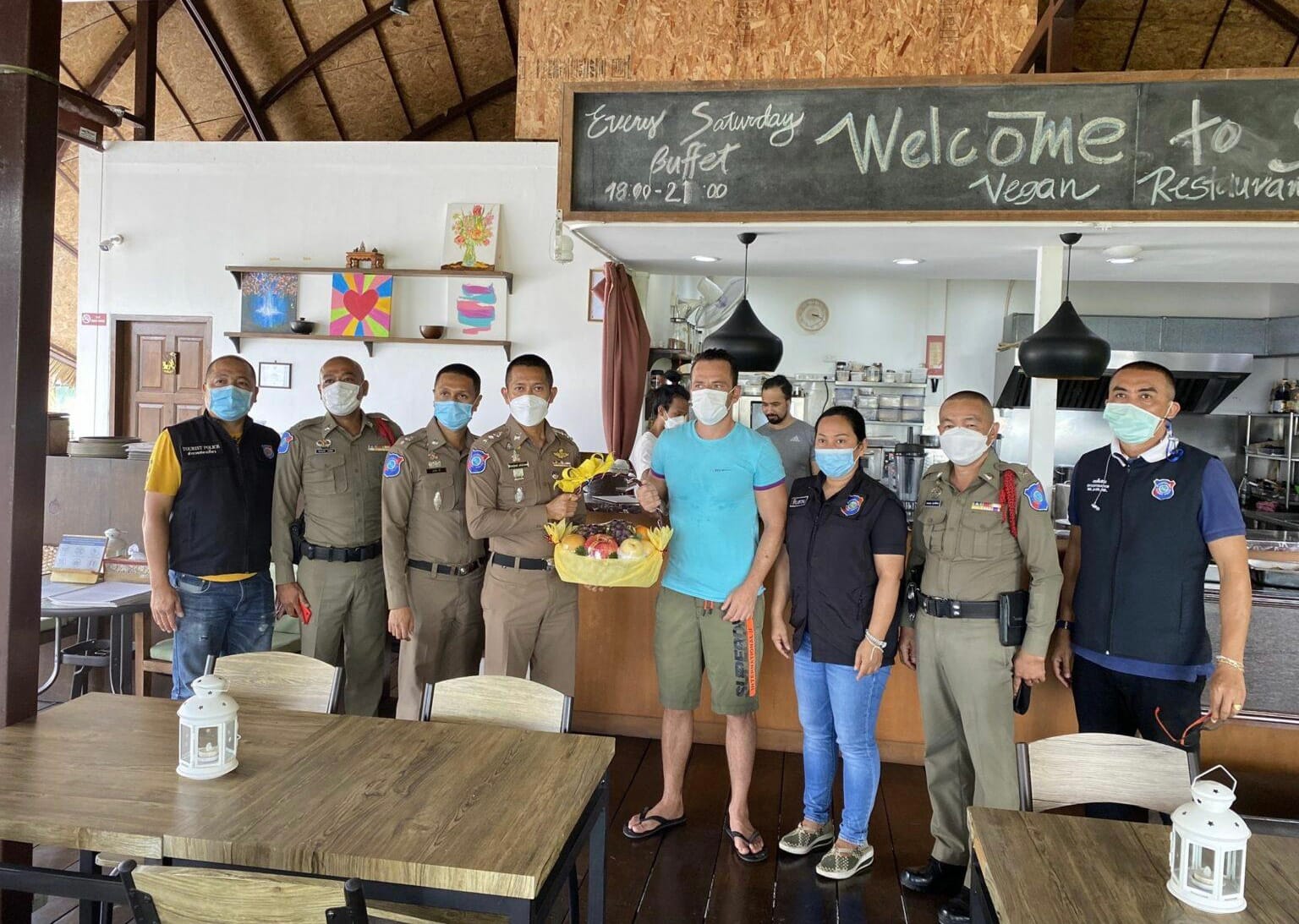 De politie van Phuket biedt een door diefstal gedupeerde Griekse familie een fruitmand aan