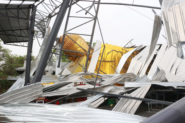 Storm in Buriram, in het noordoosten van Thailand laat het onderkomen van een groot Boeddhabeeld instorten