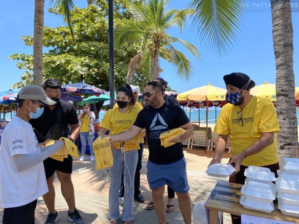 Eigenaar van een goudwinkel in Pattaya deelt op de Beach Road eten uit om de mensen in nood te helpen