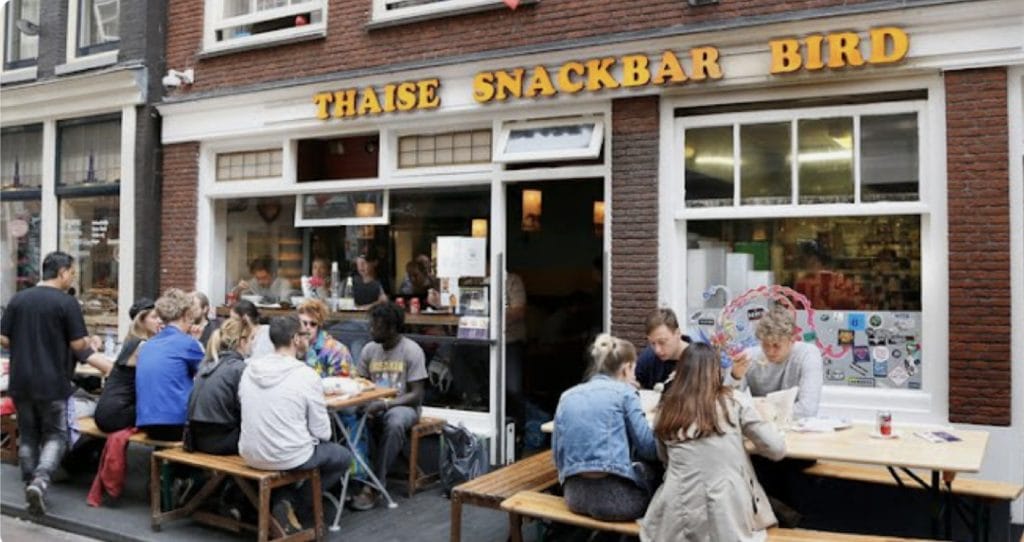 Man aangehouden die baksteen door ruiten Thaise restaurants gooide