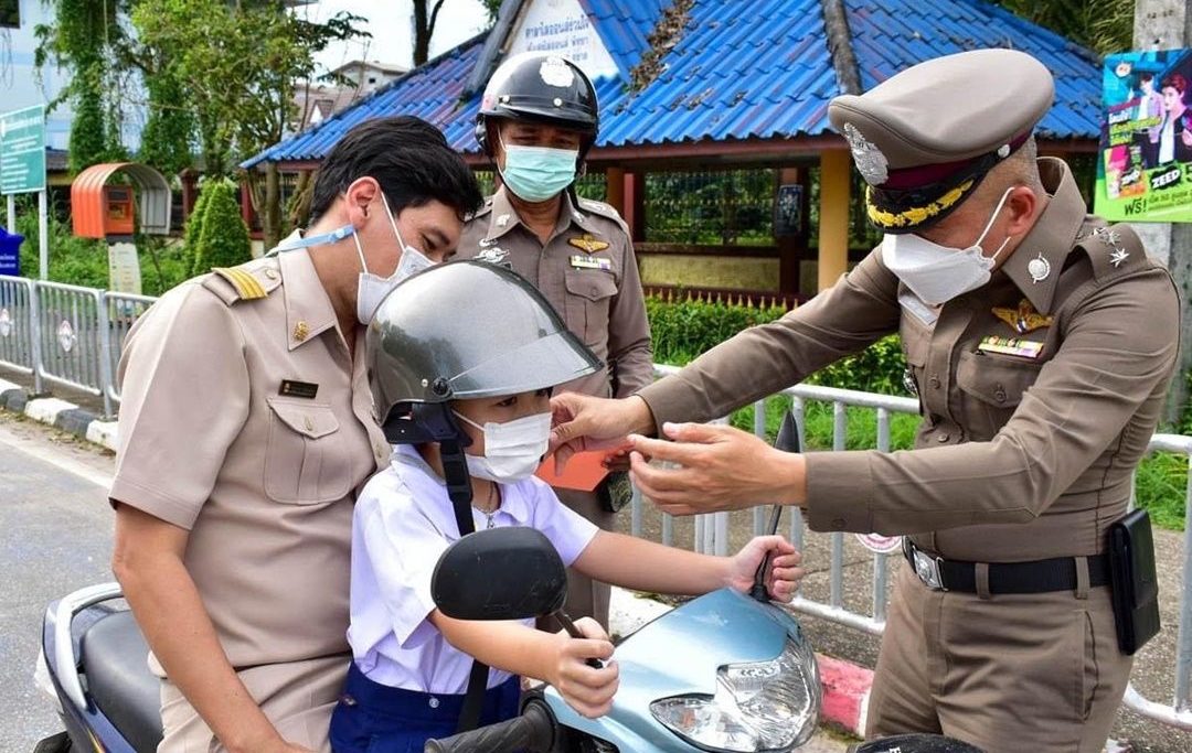Politie in Oost-Thailand geeft helmen aan motorrijders die zonder helm zijn betrapt