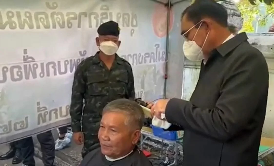 Premier Prayut geeft legerveteraan een gratis knipbeurt in Noordoost-Thailand