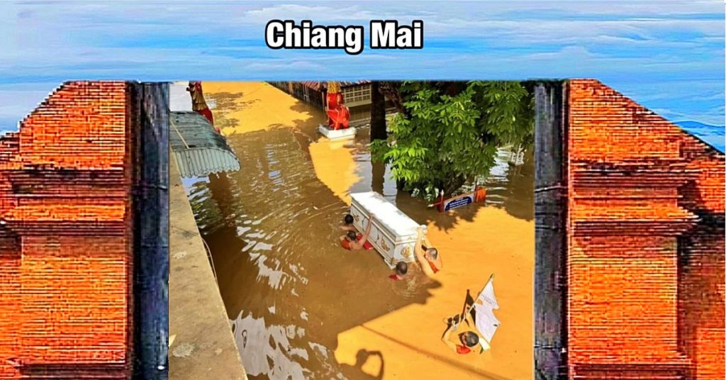 Monniken ploeteren in Noord-Thailand met een doodskist op de schouders door het water, om de kist naar de crematie tempel te brengen 