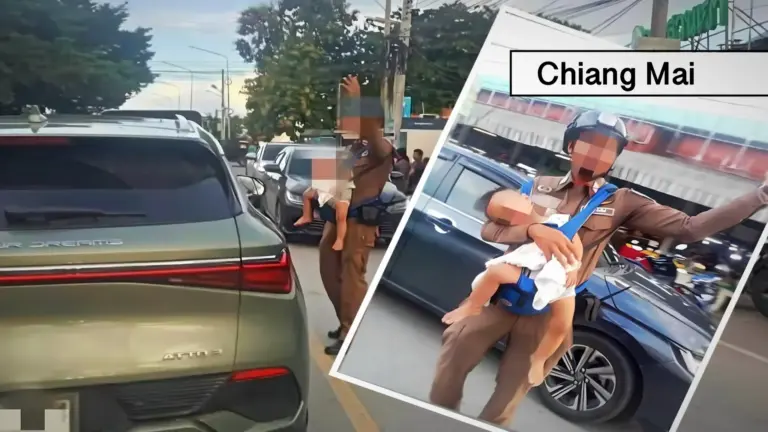 Pappadag in Thailand: verkeersvrijwilliger met baby in draagzak houdt verkeer aan de gang.