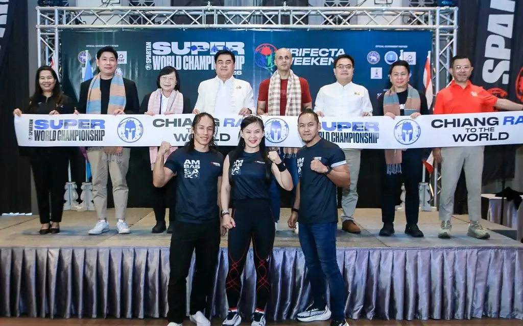 Event organizers and athletes pose with a Chiang Rai championship banner.