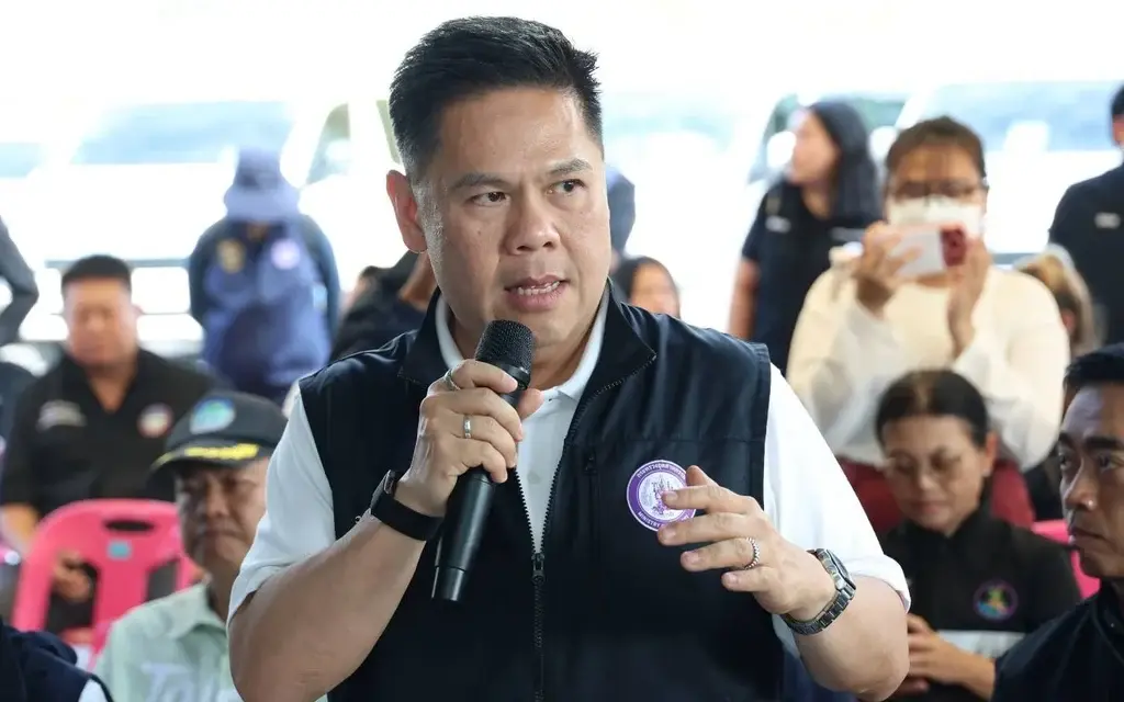 Man speaks into a microphone at a crowded public event.