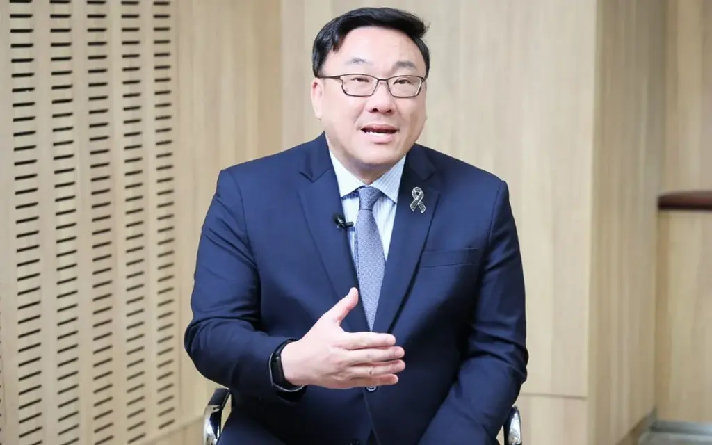 Labor minister in a navy suit speaking while seated indoors