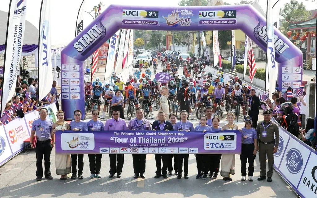 Officials holding banner at race start line with arch